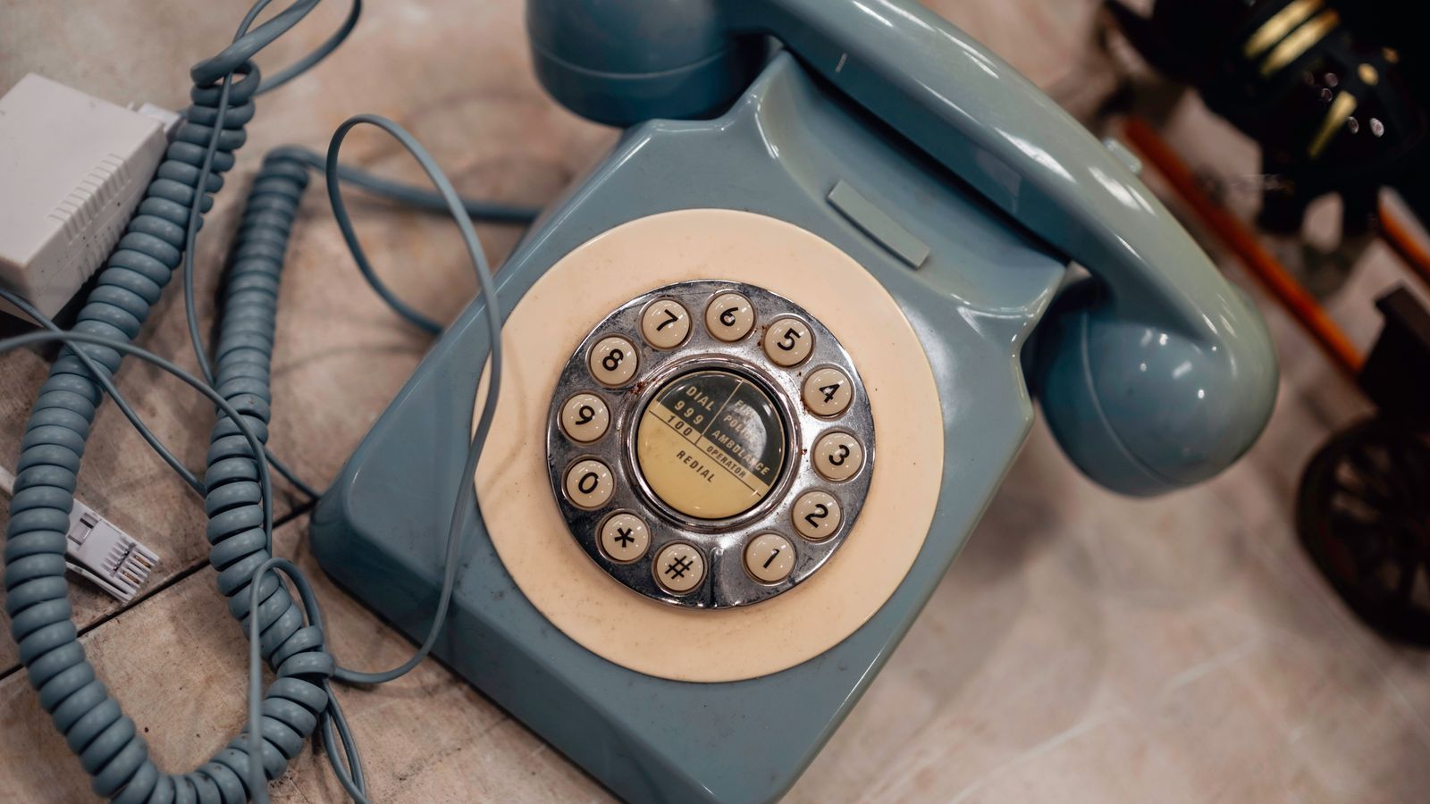 A classic blue rotary-dial telephone showcasing nostalgic telecom design.